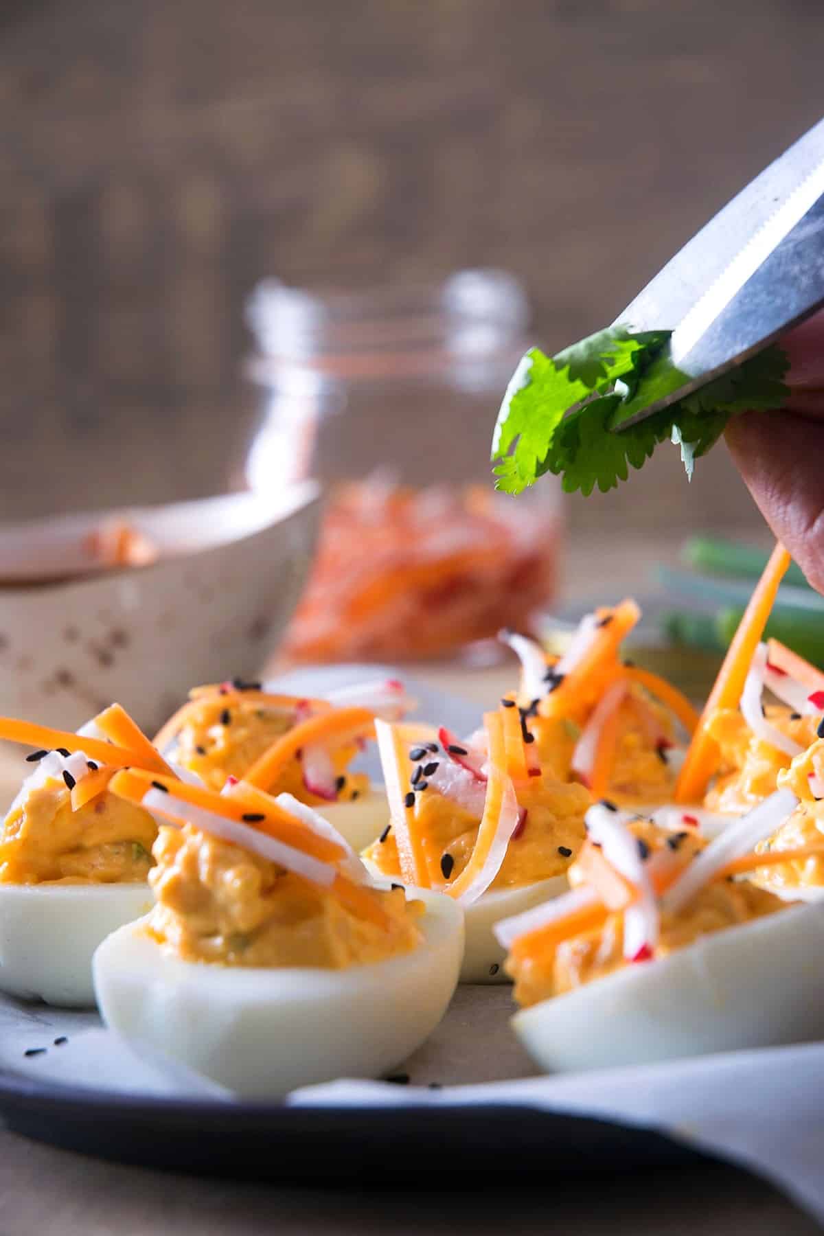 Kimchi deviled eggs and scissors cutting cilantro.