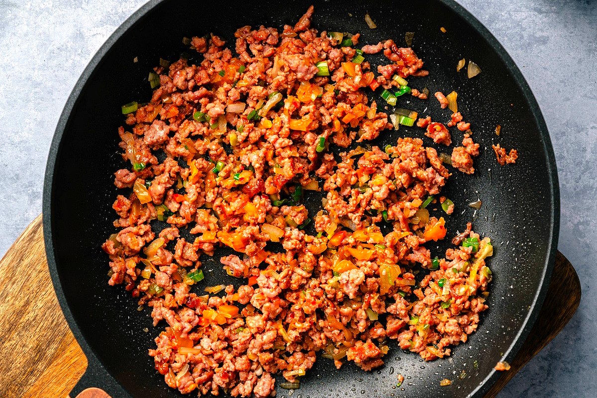 Kimchi dumpling pork filling in frying pan.