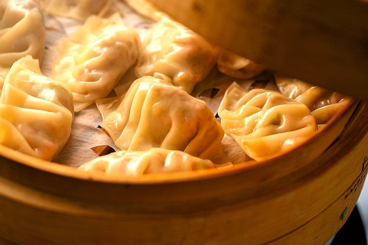 Kimchi dumplings cooked in bamboo steamer.