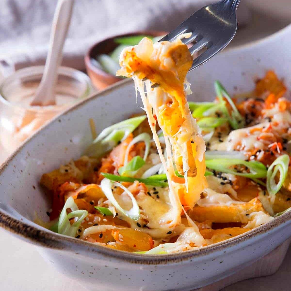 Kimchi fries with cheese in baking dish.