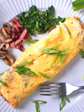 Kimchi omelette on plate with fork.