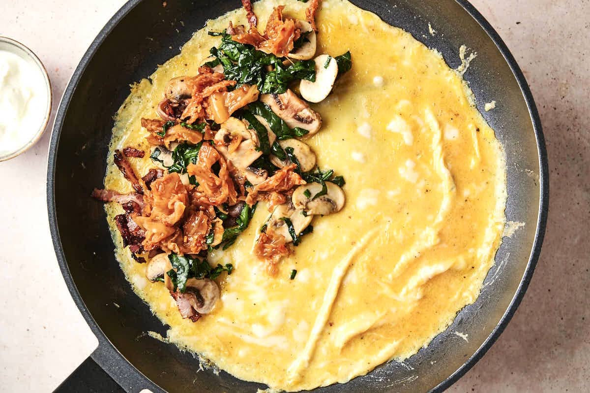 Omelette with fillings in pan.