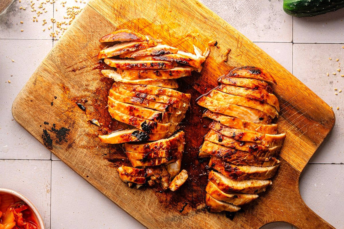 Chicken breasts sliced on cutting board.