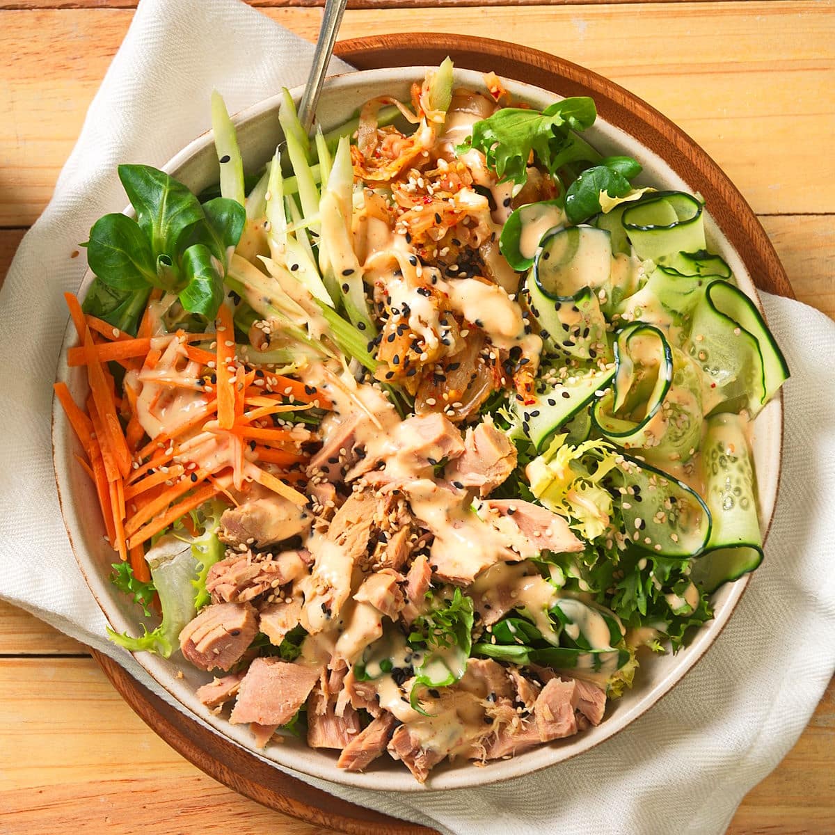Kimchi salad in salad bowl on wooden background.