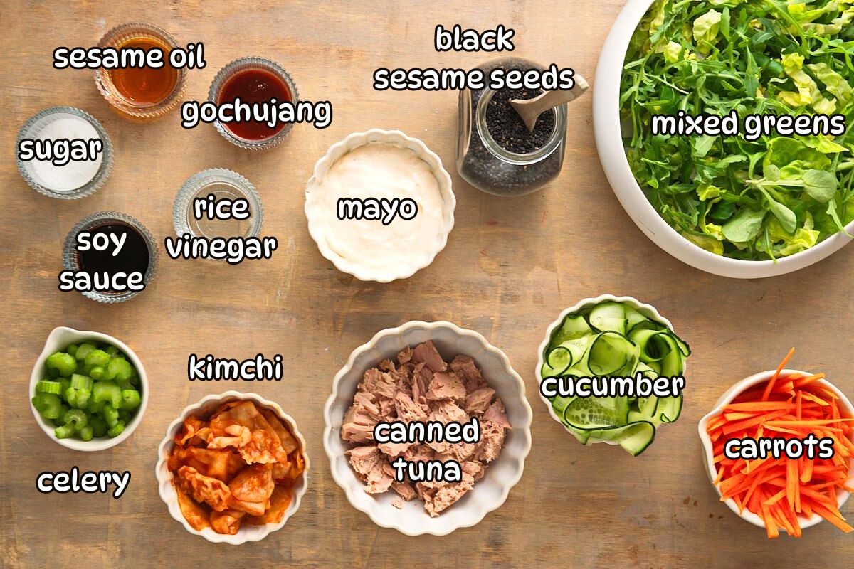 Kimchi salad ingredients prepped on brown background.