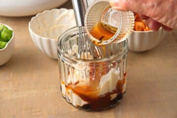 Kimchi salad dressing in jar with whisk.