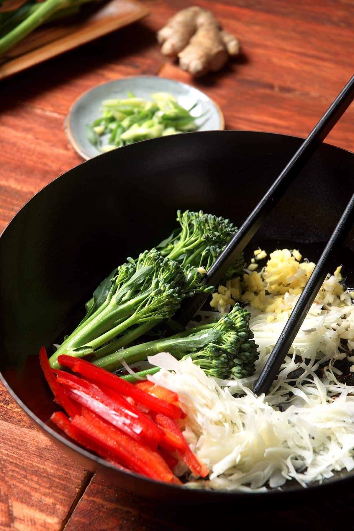 Vegetables with chopsticks in pan.