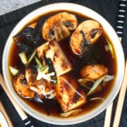 Kimchi tofu vegan soup in white bowl.