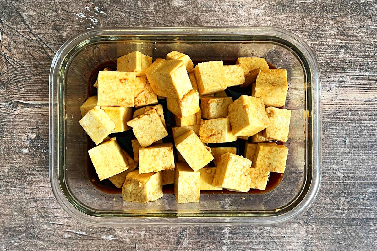 Cubed tofu marinating in dish.