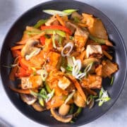 Kimchi and tofu stir fry in black dish.