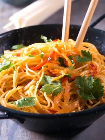 Kimchi udon in a bowl with chop sticks.