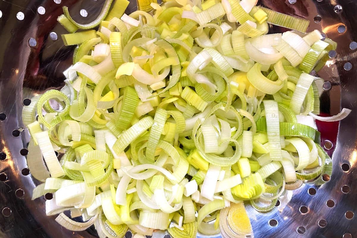 Sliced, cleaned leeks in colander.