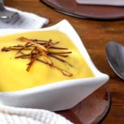 Leek and potato soup in a white bowl.