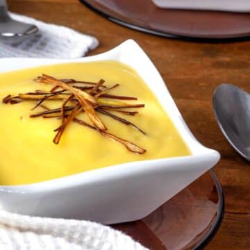 Leek and potato soup in a white bowl.