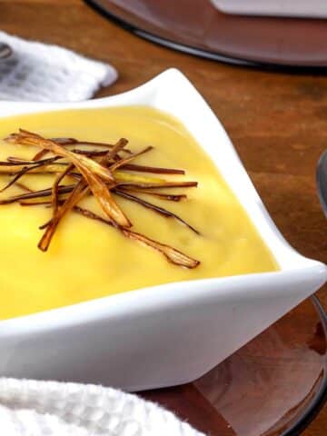 Leek and potato soup in a white bowl.
