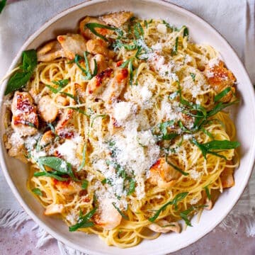 Lemon basil pasta with chicken and Parmesan cheese on plate.