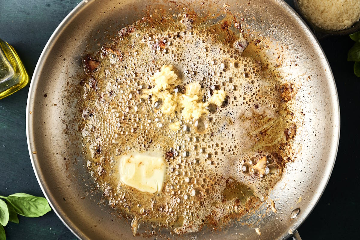 Butter melying with garlic in pan.