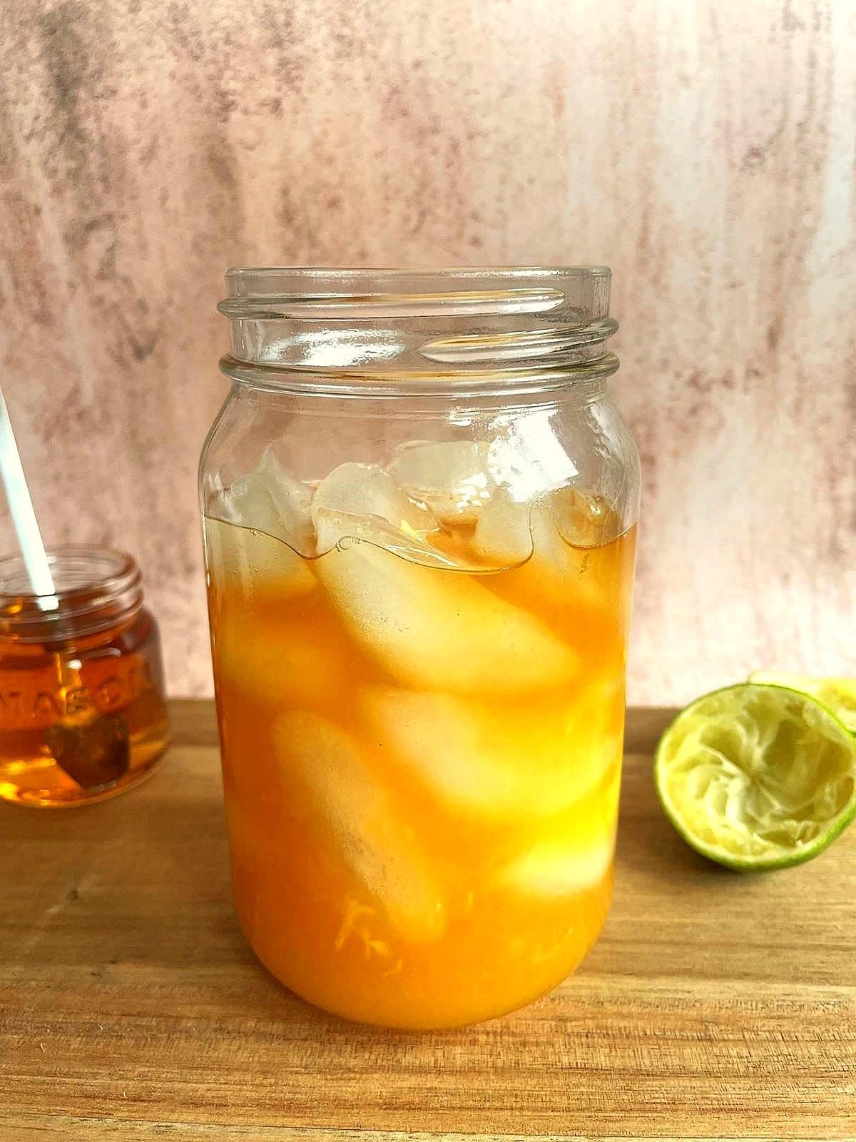 Glass filled with mango ginger cocktail ingredients.