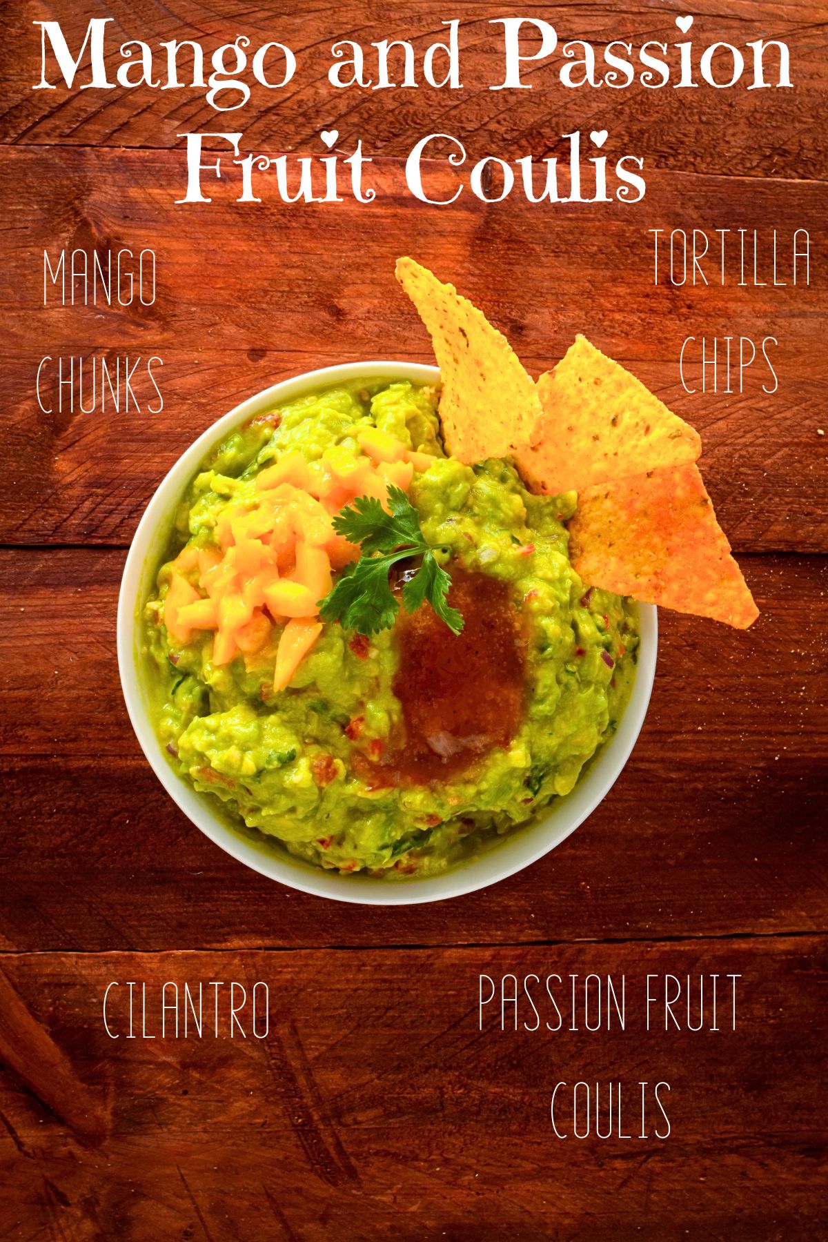 Mango chunks, coulis and tortilla chips on top of guacamole in a bowl.