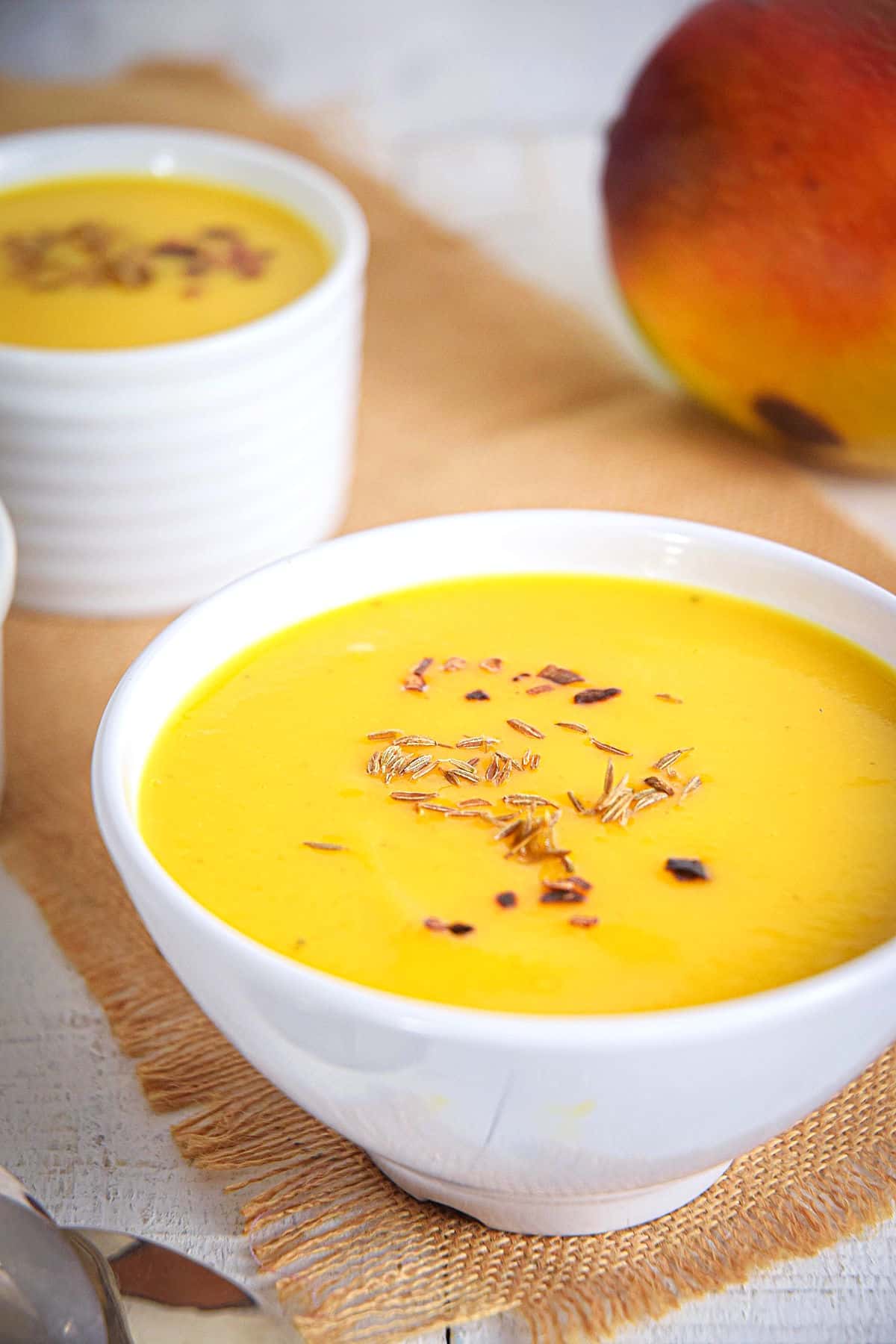 Mango soup in white bowl.