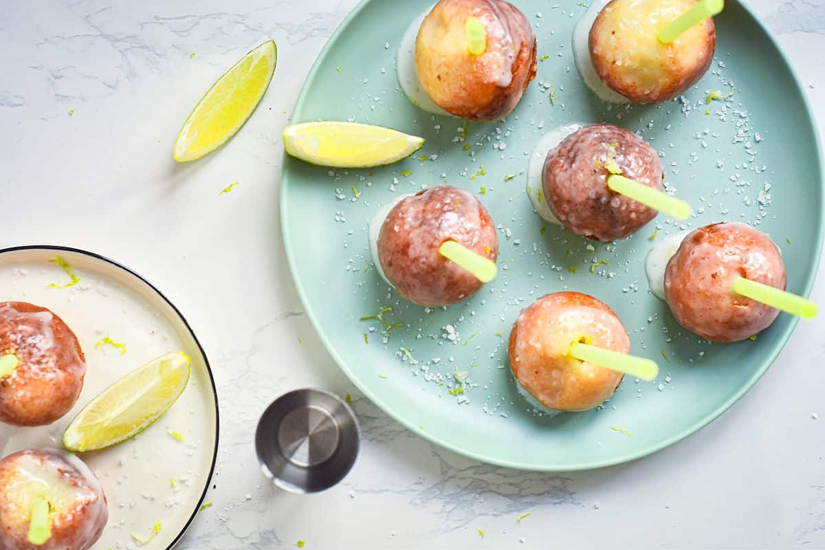 Margarita cake pops on plate with lime wedges and sea salt.