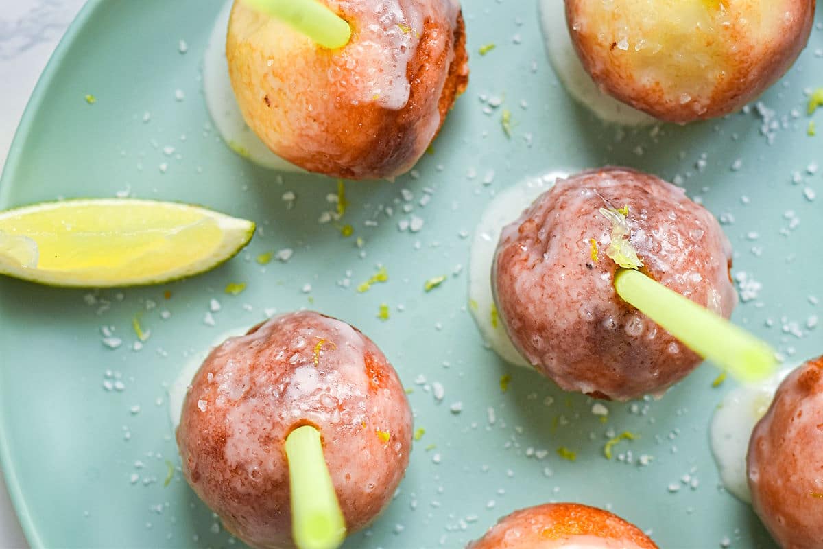 Margarita cake pops on plate with lime wedge.