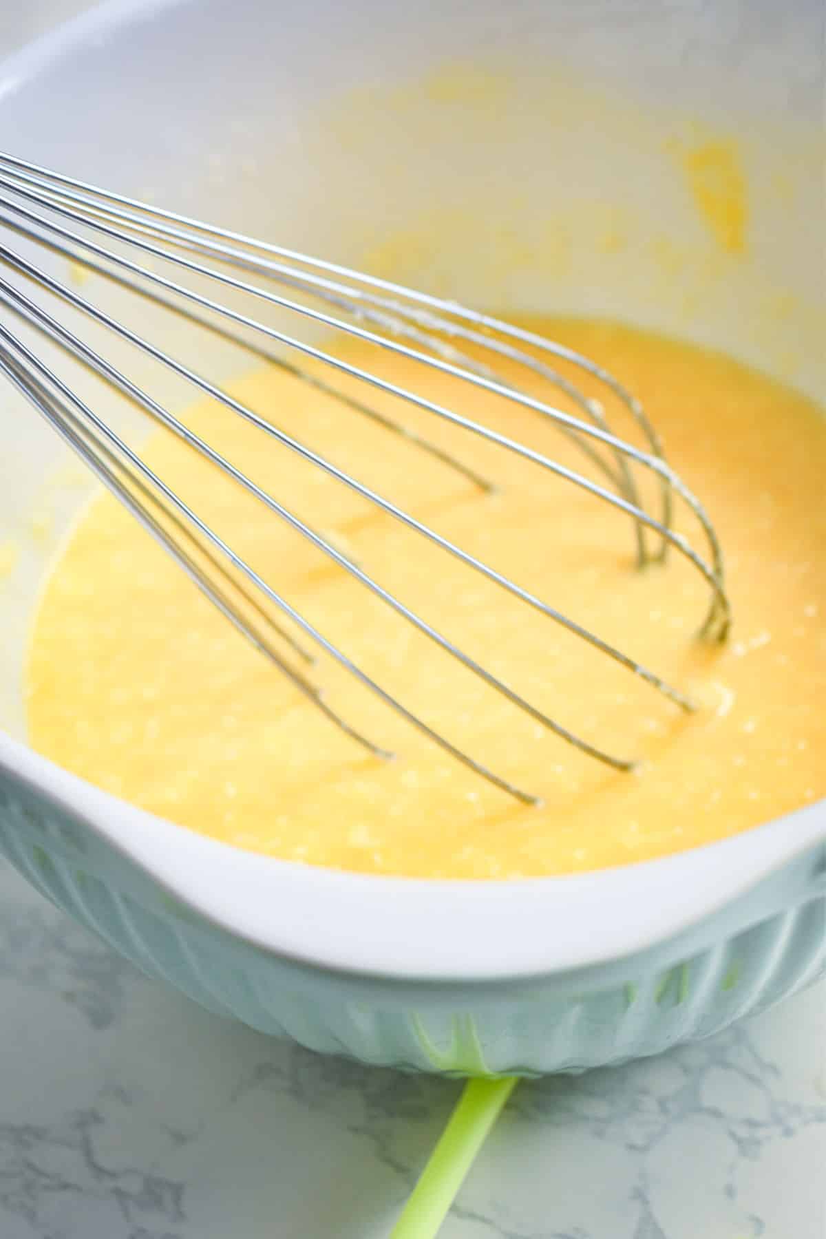 Margarita cake pop batter liquid ingredients in bowl with whisk.