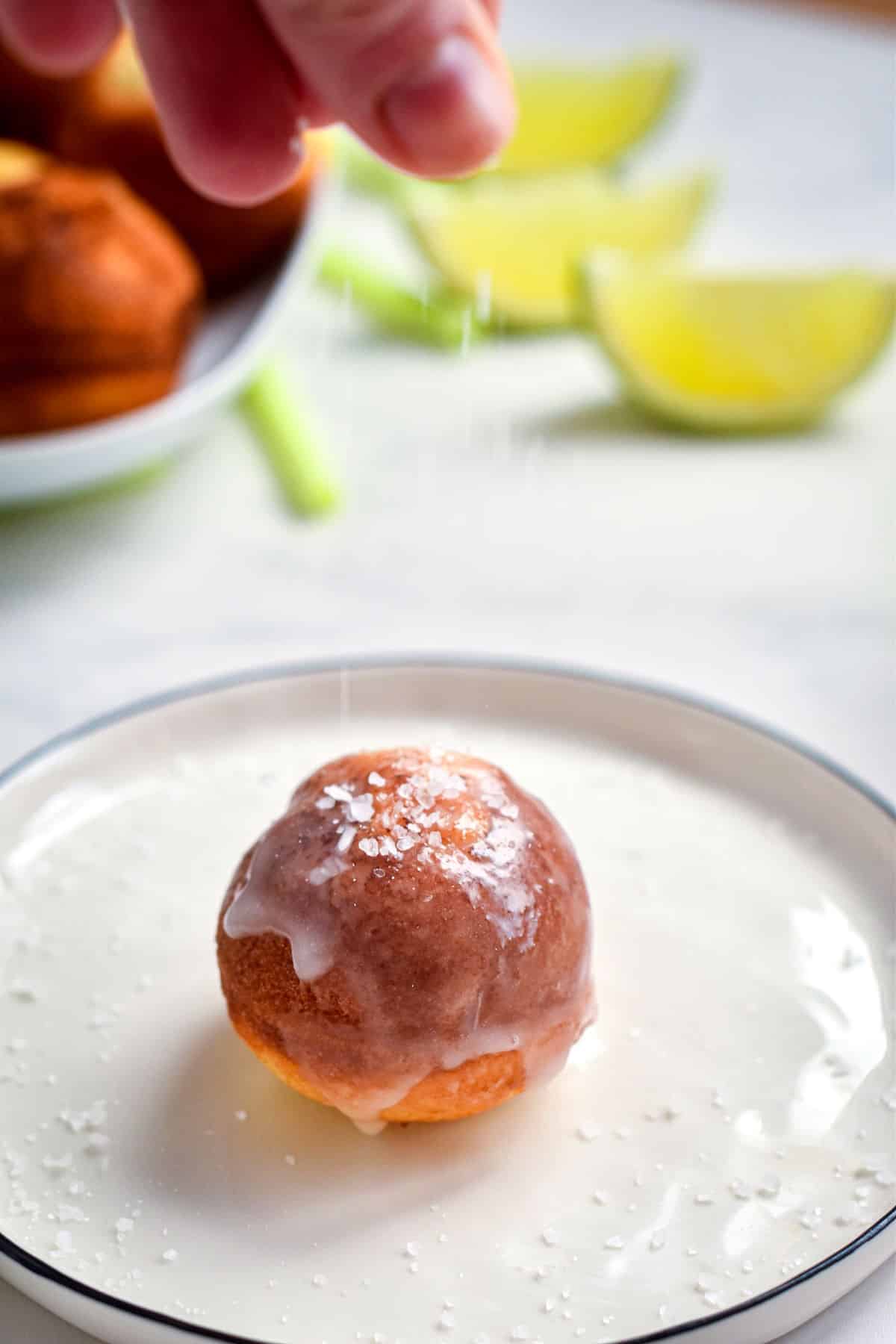 Margarita cake ball on plate with glaze and sea salt.