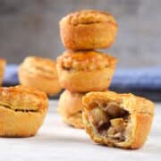 Mini apple pies stacked and one sliced open.