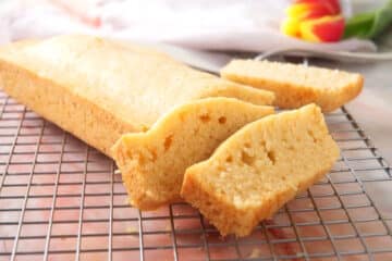 Pancaked bread loaf sliced on baking rack.