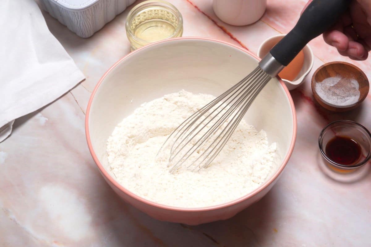 Pancake bread batter dry ingredients in bowl with whisk.