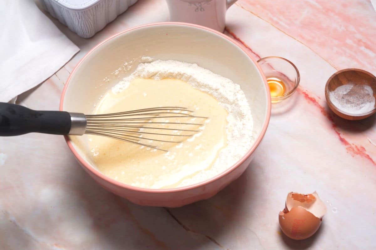 Pancake batter in bowl with whisk.