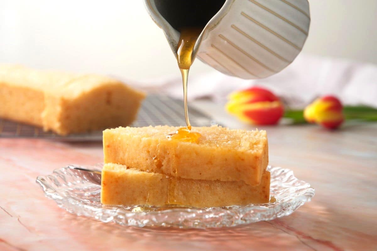 Pancake syrup pouring over pancake bread slices.