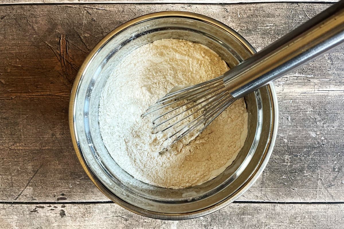 Dry muffin mixture in bowl with whisk.
