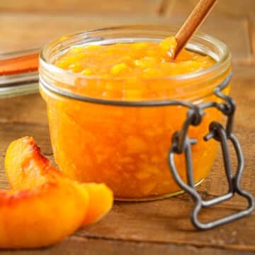 Peach freezer jam in jam jar with the lid off.