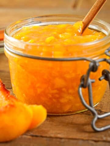 Peach freezer jam in jam jar with the lid off.