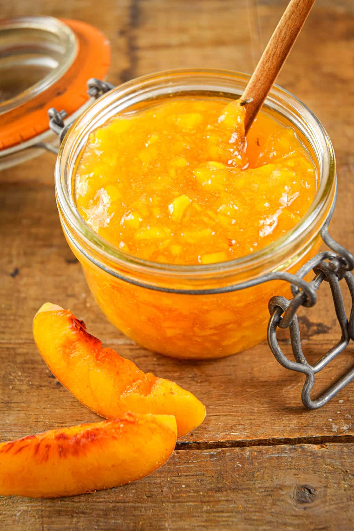 Peach freezer jam in jam jar with spoon.