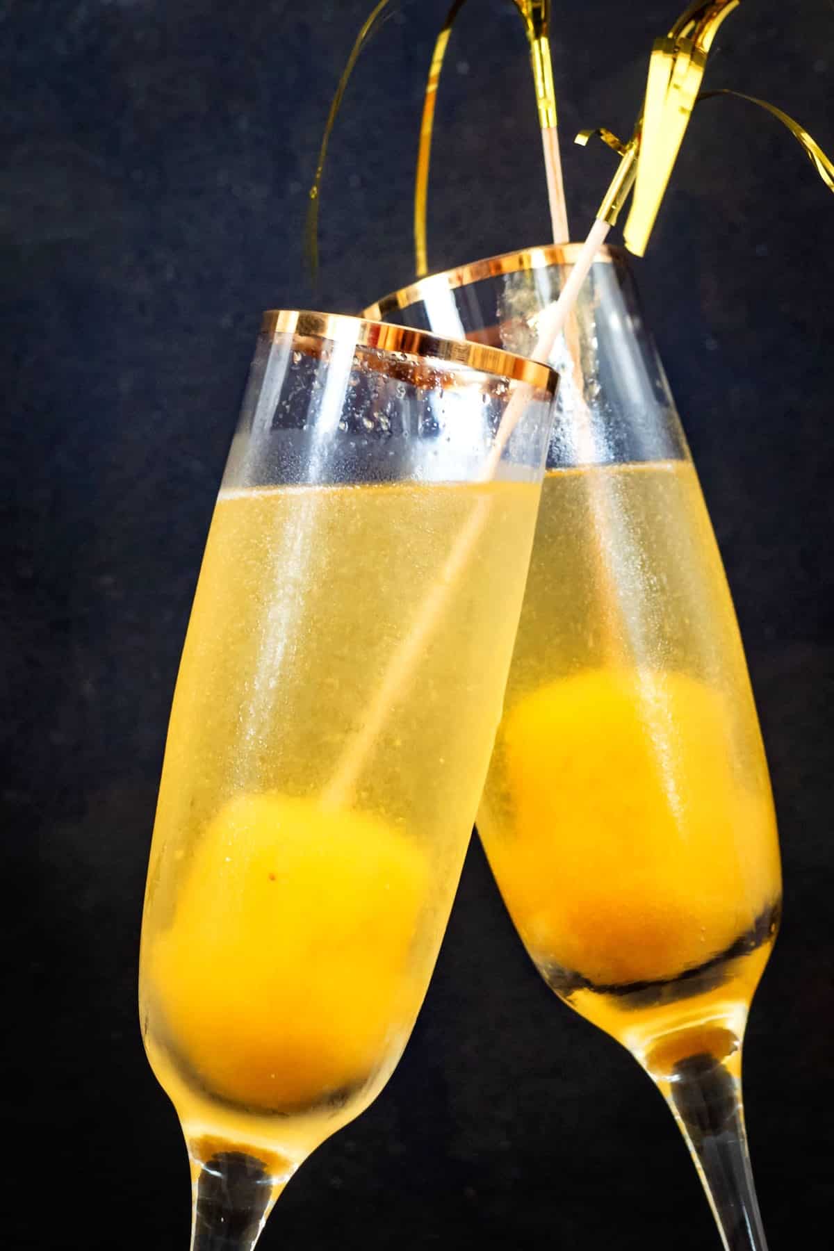 Peach Bellinis on black background.