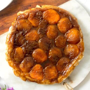 Peach tarte tatin on marble/wooden serving board.