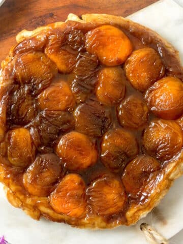 Peach tarte tatin on marble/wooden serving board.