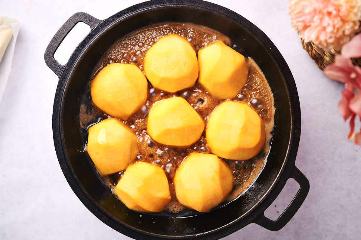 Caramel sauce and peaches in pan.