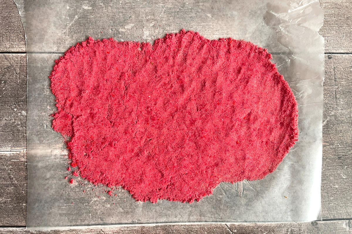 Pink sugar rim spread out on wax paper.