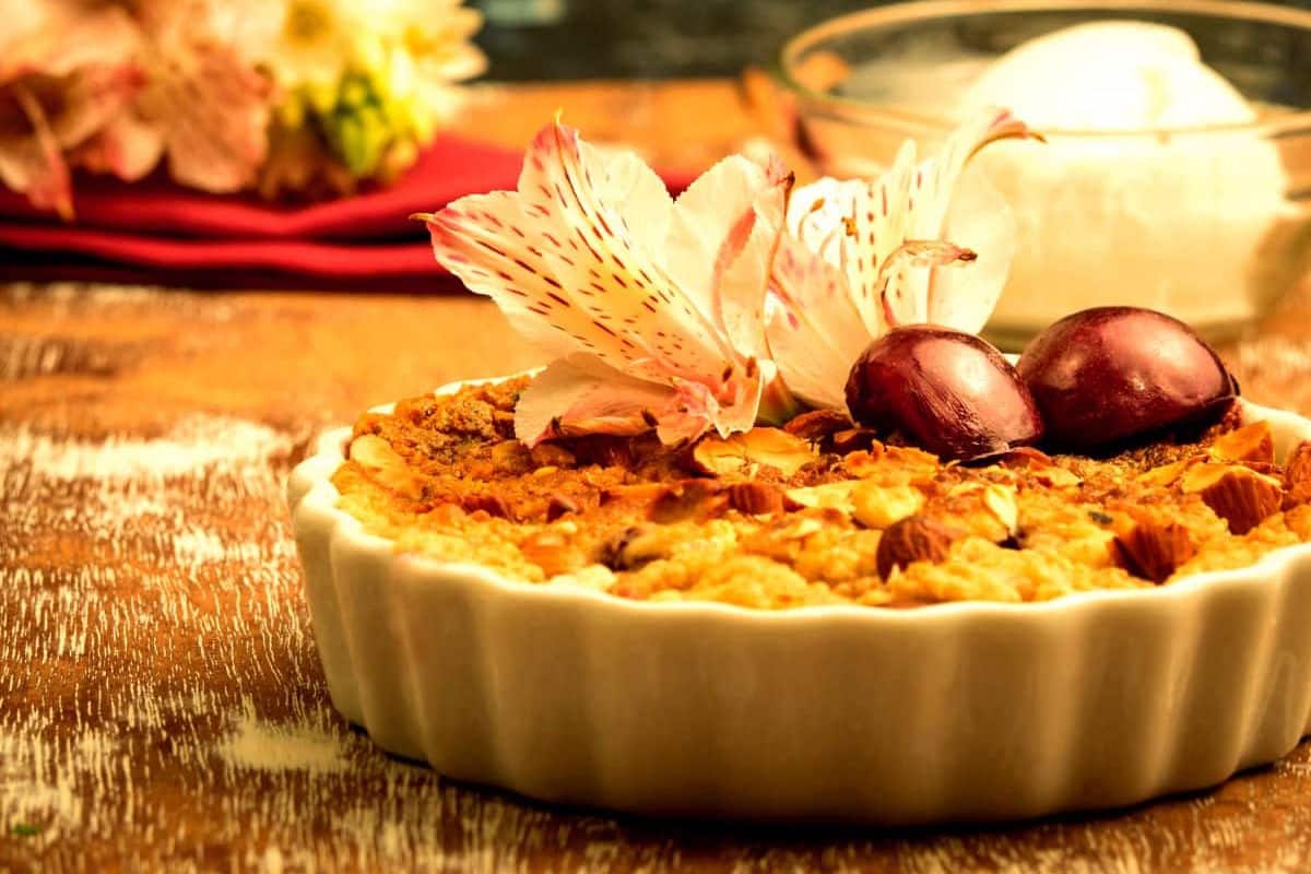 Baked plum crumble with a bowl of ice cream on the side.