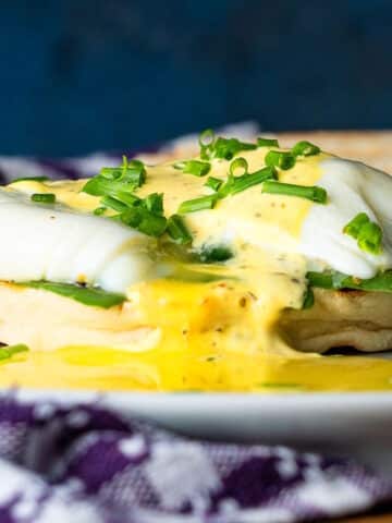 Runny poached eggs on an English muffin with mock bearnaise sauce.