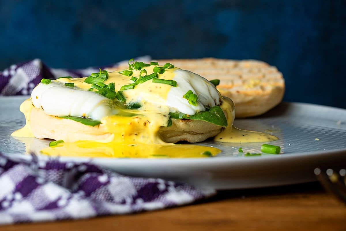 Runny poached eggs on an English muffin with mock bearnaise sauce.