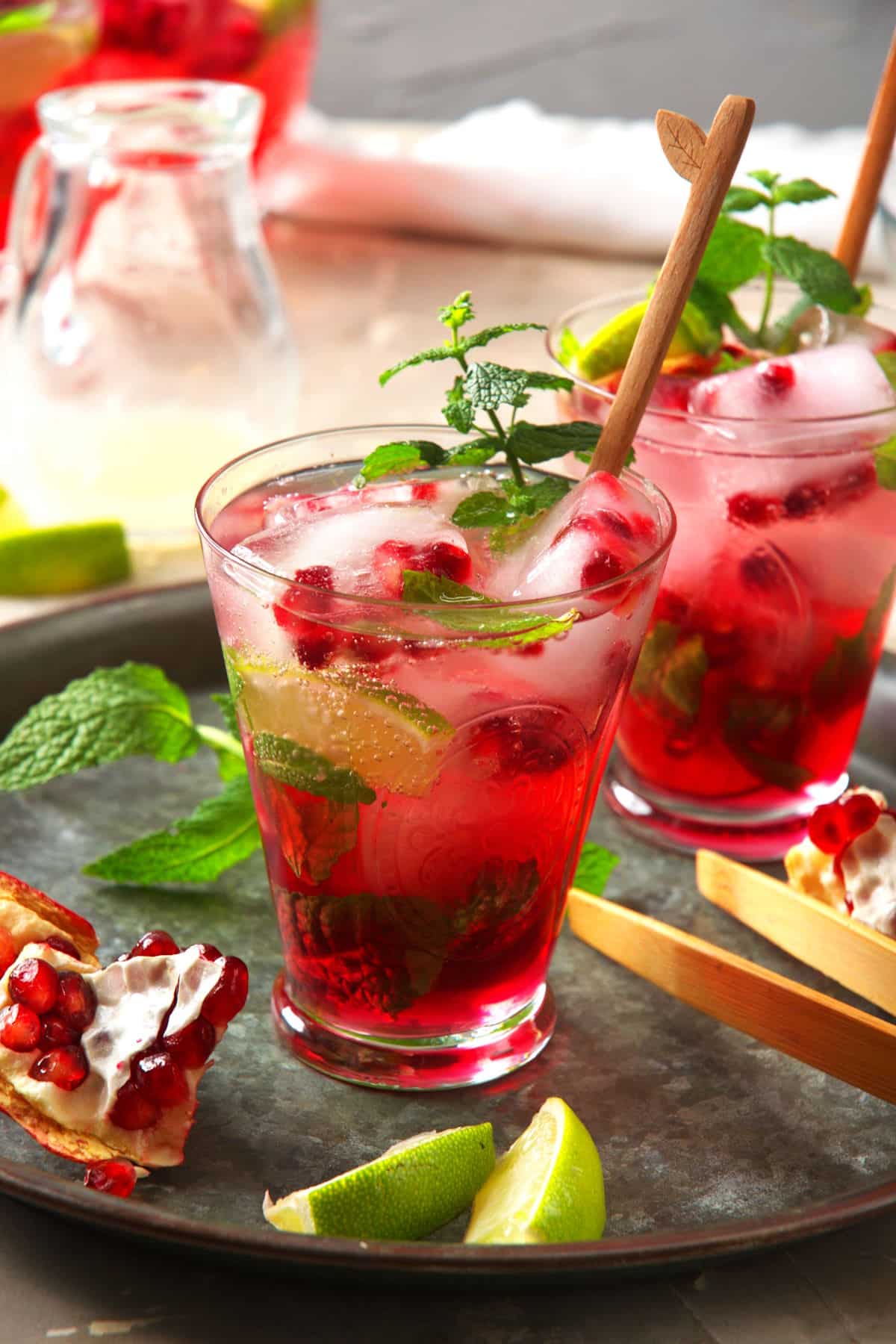 Pomegranate mojito mocktail in glass with mint and lime.