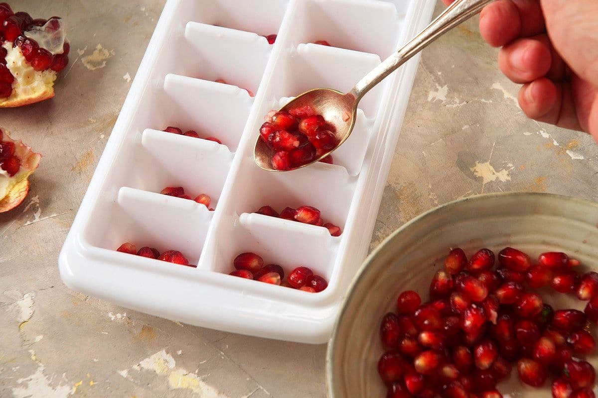 Pomegranate seeds in ice cube tray.