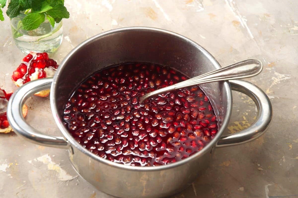 Pomegranate syrup in saucepan.