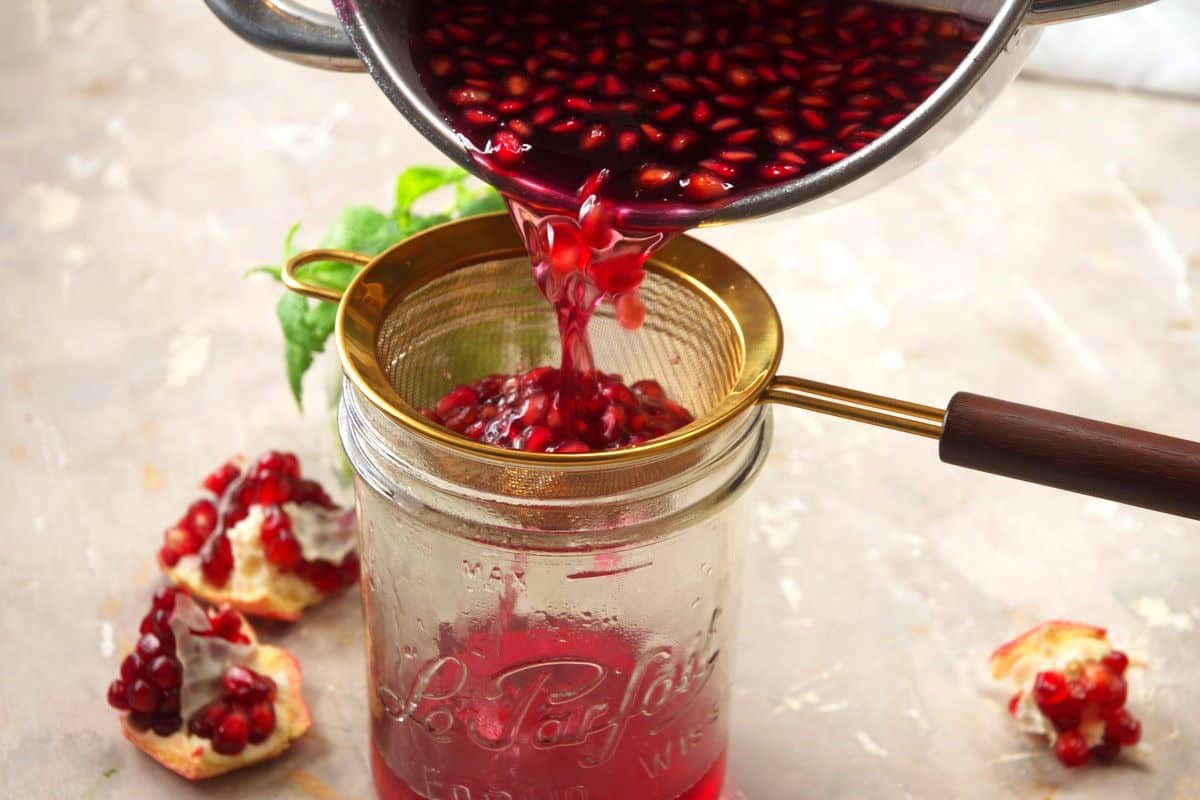 Pomegranate syrup straining into jar.