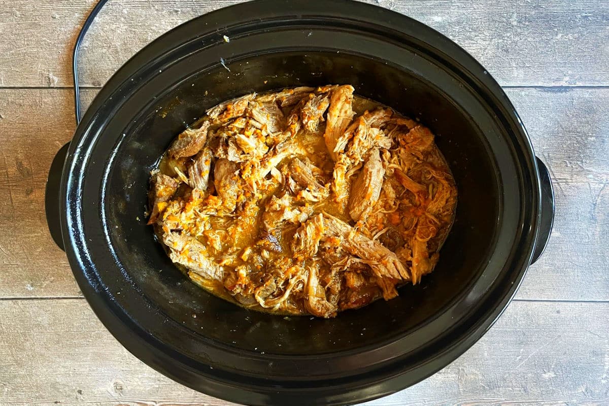 Pulled pork with sauce in slow cooker.